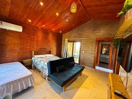 a bedroom with a bed and a couch in it at Bem te quero Pipa- apt superior in Pipa