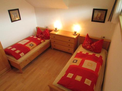 a bedroom with two beds and a dresser with lights at Juniorland II in Wagrain