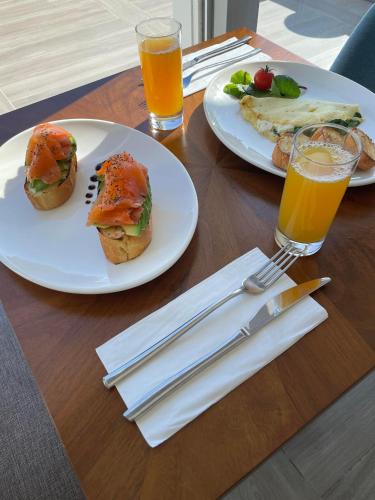 two plates of sandwiches and two glasses of orange juice at Bliss Boutique Living in Xagħra
