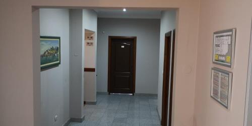 a hallway with a door and a room with a tile floor at Hotel Elegance in Belgrade