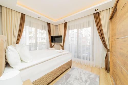 a hotel room with a bed and a tv at Comfy Flat with Balcony Close to Konyaalti Beach in Antalya