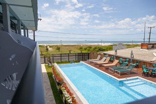 a swimming pool with a view of the ocean at Pousada Guaricana in Pontal do Paraná
