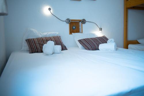 Una cama con dos ositos de peluche encima. en Wax Hostel en Faro