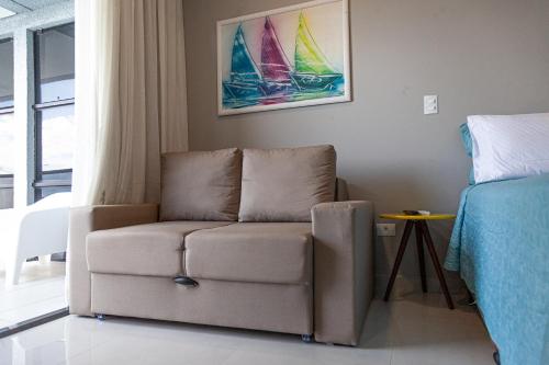 a living room with a couch and a bed at Pousada Guaricana in Pontal do Paraná