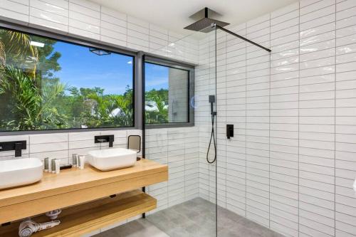 a bathroom with two sinks and a shower at Slowlife Wellness Villa! in Baie Longue