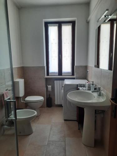 łazienka z 2 umywalkami, toaletą i lustrem w obiekcie Mary House w mieście Negrar