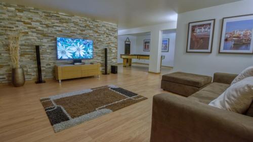 a living room with a couch and a flat screen tv at 8-Bed Villa in Vilamoura-Sleeps-Playground-Pool in Vilamoura