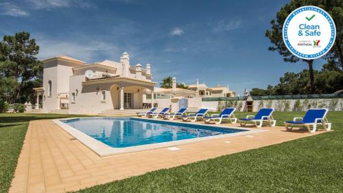 a villa with a swimming pool in front of a house at 8-Bed Villa in Vilamoura-Sleeps-Playground-Pool in Vilamoura