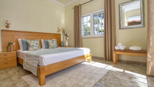 a bedroom with a large bed and a window at 8-Bed Villa in Vilamoura-Sleeps-Playground-Pool in Vilamoura