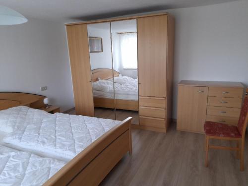 a bedroom with a bed and a dresser and a mirror at Ferienwohnung Hille in Arendsee