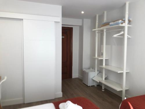 a bedroom with white shelves and a red rug at Pensión Amara in Donostia-San Sebastián