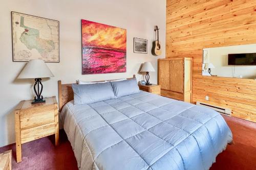 um quarto com uma grande cama azul e paredes de madeira em The Inn at Silvercreek 633 em Granby