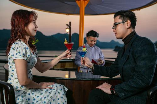 a man and a woman holding drinks at a bar at Nostalgia Halong Cruise in Ha Long