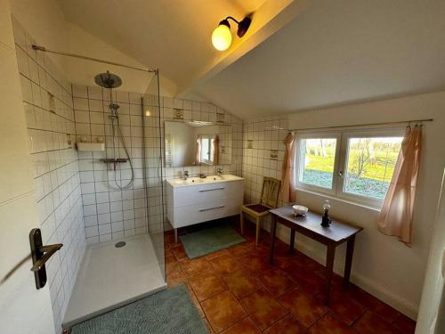 La salle de bains est pourvue d'un lavabo, d'une douche et d'une table. dans l'établissement Gîte Périgourdin la Picherie, à Montpon-Ménestérol