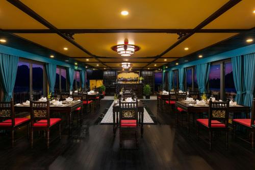 a restaurant with tables and chairs and a chandelier at Nostalgia Halong Cruise in Ha Long