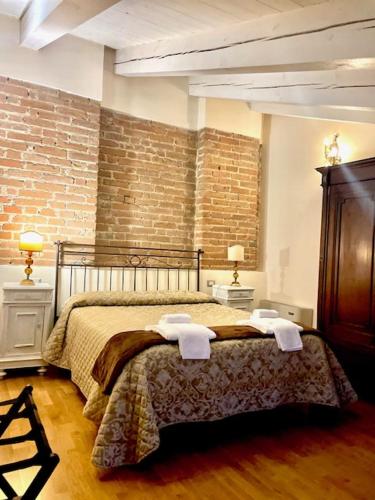 a bedroom with a bed with towels on it at Relais Palazzo Paleologi Sec.XIV in Lu