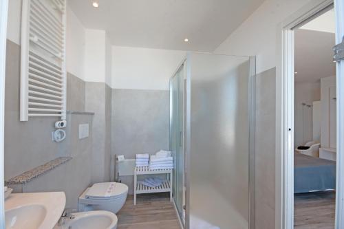 a bathroom with a shower and a toilet and a sink at Hotel Kent in Riccione