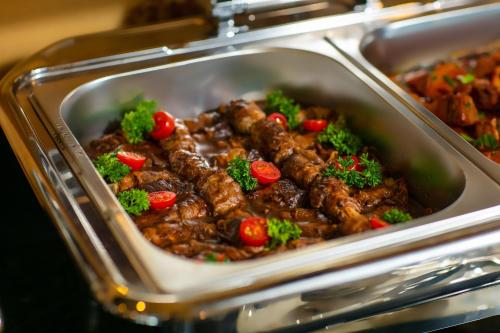 a dish of meat and vegetables in a container at Nostalgia Halong Cruise in Ha Long