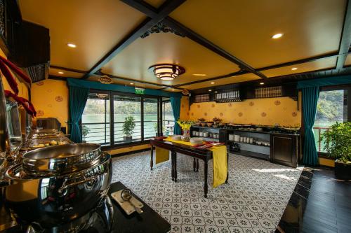 a kitchen with a table in the middle of a room at Nostalgia Halong Cruise in Ha Long