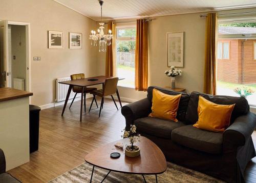 a living room with a couch and a table at Bluewood Lodges in Kingham