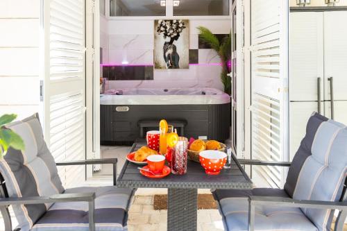 una mesa con un bol de fruta y una bañera en Apartment Zolla Dubrovnik- Hot Tub and Free Parking, en Dubrovnik