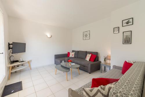 a living room with a couch and a table at Le Verger, villa lumineuse et agréable avec son espace extérieur clos au cœur de notre vignoble in Hyères