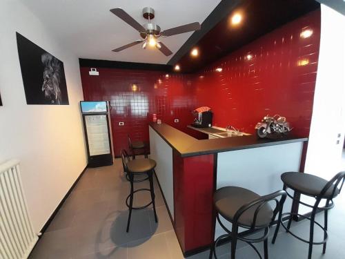 een bar met krukken en een rode muur bij Green D`Or B&B in Montone
