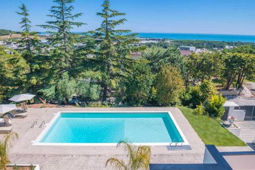 a swimming pool in a yard with trees and the ocean at Green D`Or B&B in Montone