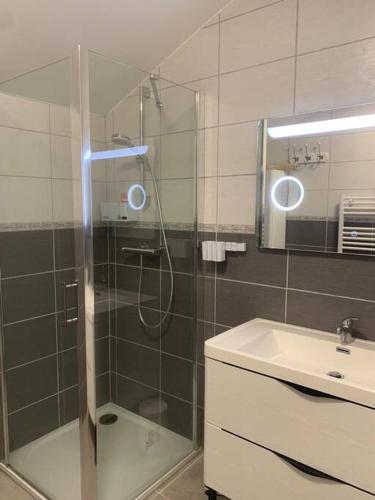 une salle de bain avec douche et lavabo dans l'établissement Cottage les petites voiles plage, à Agon-Coutainville
