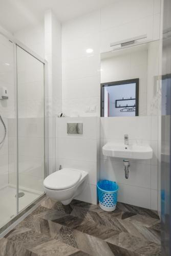a bathroom with a toilet and a sink and a shower at Zefiro Seredyńskiego in Gdańsk