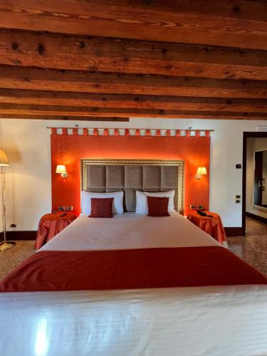 a bedroom with a large bed with an orange headboard at Ruzzini Palace Hotel in Venice