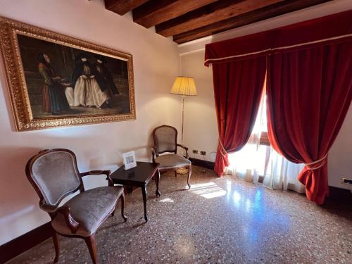 a living room with chairs and a painting on the wall at Ruzzini Palace Hotel in Venice