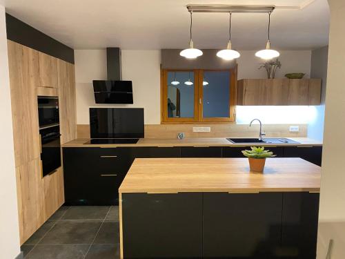 a kitchen with black cabinets and a counter top at Le Chalet Carpe Diem in Le Bourg-dʼOisans