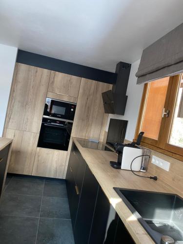a kitchen with wooden counter tops and a sink at Le Chalet Carpe Diem in Le Bourg-dʼOisans