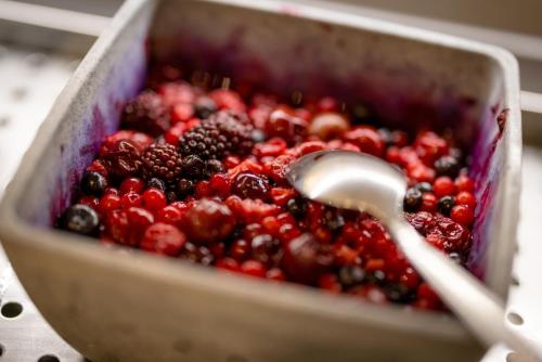 a pan full of berries with a spoon in it at Hôtel Méditerranée in Calvi