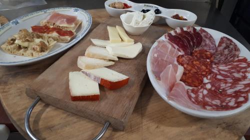 a wooden cutting board with different types of meats and cheese at Agriturismo Fonte Magria in Abbadia San Salvatore