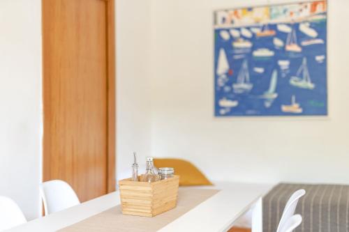 a white table with a wooden basket on top of it at Le Grand Bleu - Gioia Apartments in Procida