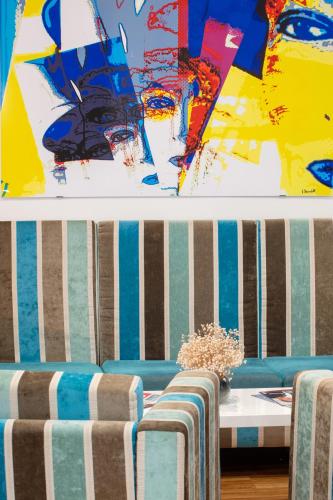 a room with two chairs and a table and a painting at Hôtel Méditerranée in Calvi