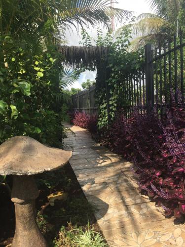 a garden with a fence and a stone walkway at B&B Verger Vannary in Phumĭ Băk Chĕnhchiĕn