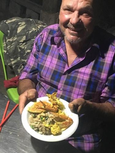a man sitting at a table with a plate of food at B&B Verger Vannary in Phumĭ Băk Chĕnhchiĕn