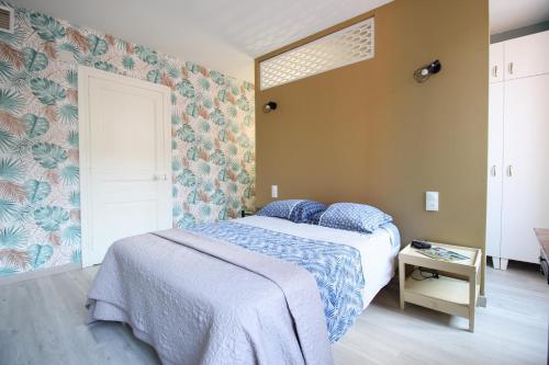 um quarto com uma cama com um cobertor azul em L'Ostalada em Albi