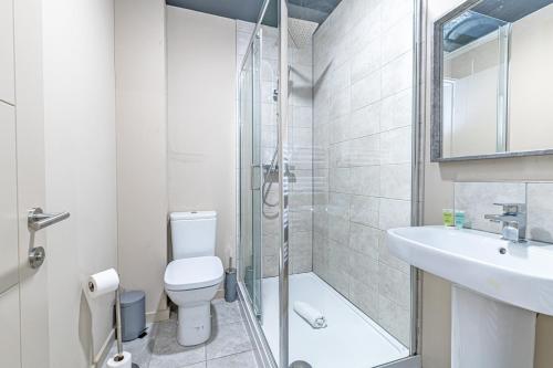 a bathroom with a shower and a toilet and a sink at Wigan Central Serviced Apartments in Wigan