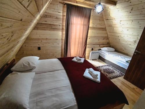 a bedroom with a bed in a wooden cabin at Planinska kuća "Soko' Romanija" in Pale
