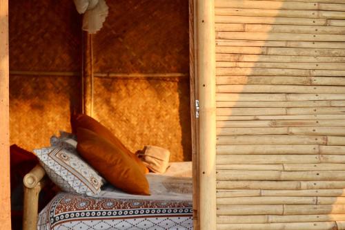 Cette chambre comprend un lit avec des oreillers et un mur. dans l'établissement Happy Lemon Tree lodge, à Sauraha