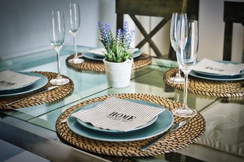 una mesa de cristal con platos y copas de vino. en Stay in Paradise Luxury Apartment, en Marbella