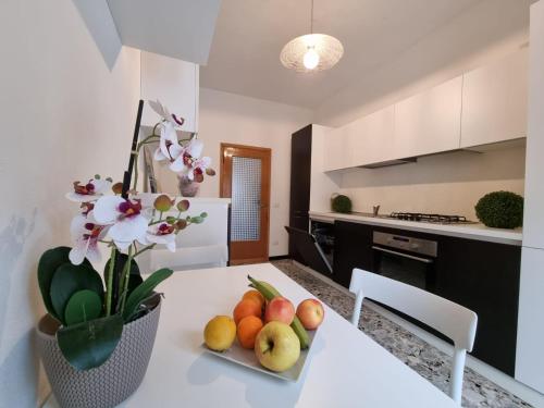 - une cuisine avec une table avec des fruits et des fleurs dans l'établissement Appartamento al Centro Storico di San Marino, à Saint-Marin