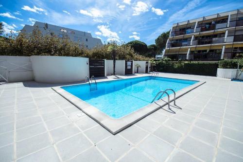 basen na patio obok budynku w obiekcie Chez Claude - Joli studio cabine climatisé avec parking et piscine w mieście La Grande-Motte