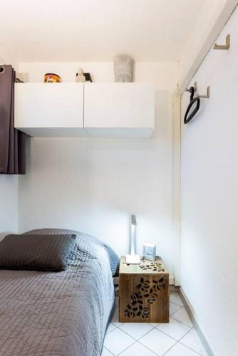 - une chambre avec un lit et une table de chevet dans l'établissement Chez Claude & Isabelle - Joli studio cabine climatisé avec parking et piscine, à La Grande Motte