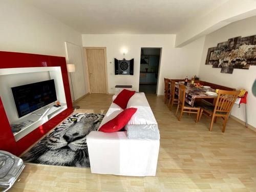 ein Wohnzimmer mit einem weißen Sofa und roten Kissen in der Unterkunft Casa vacanza Veronica con giardino in Verbania