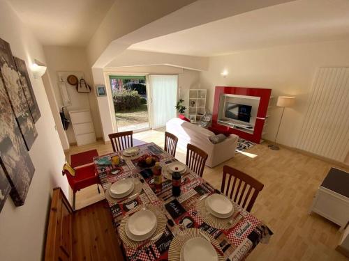 ein Wohnzimmer mit einem Tisch und Stühlen sowie ein Wohnzimmer in der Unterkunft Casa vacanza Veronica con giardino in Verbania